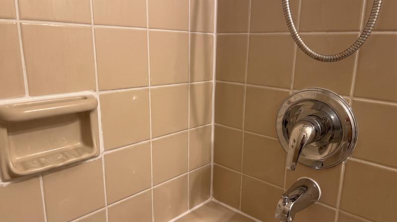 The same bathroom refreshed with new fixtures, tile work and paint