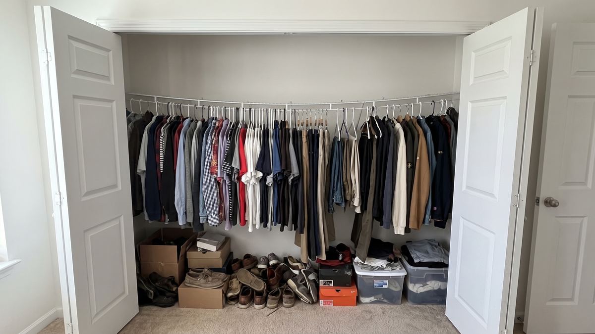 Reach-in closet with one sagging wire shelf and clutter on the floor