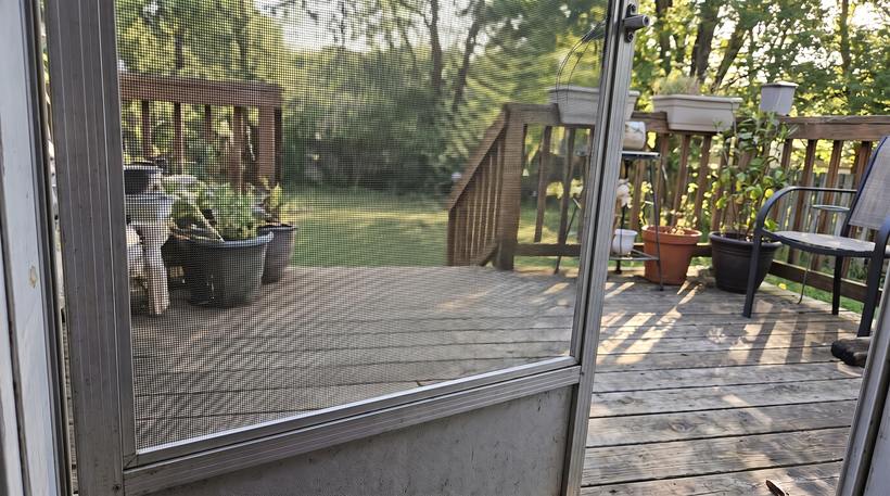 The same screen door with new mesh rolled in tight and the door hanging straight