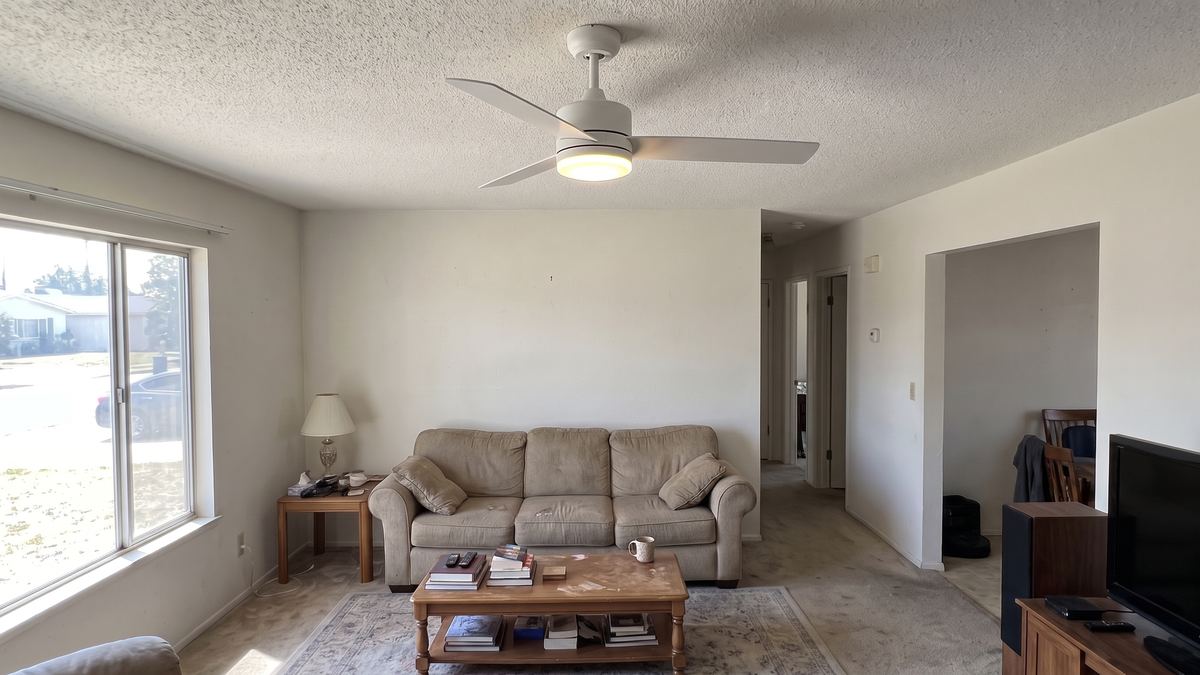 Same living room with a new white ceiling fan with an LED light installed