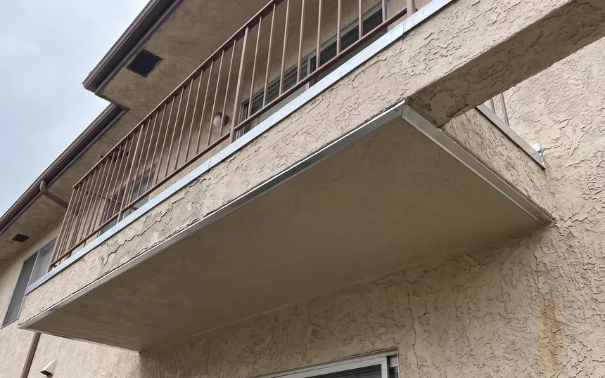 After: the same balcony reframed, recoated and its guardrail re-anchored