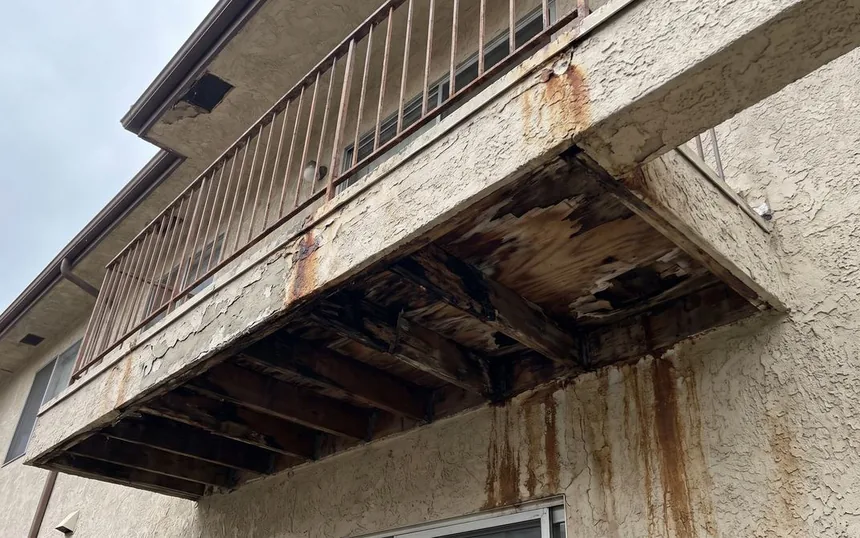 Before: an apartment balcony with rotted joists and a deck gone soft at the edge