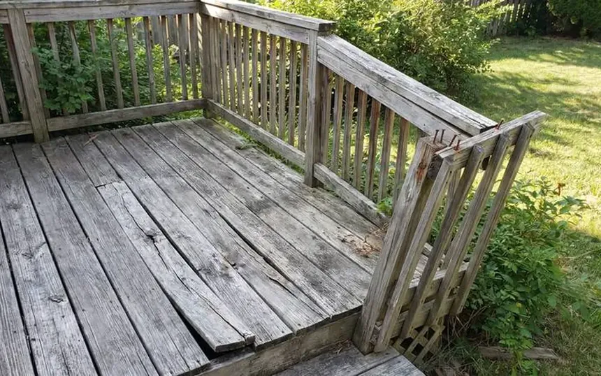 Before: a deck with a loose guardrail post and weathered, split boards