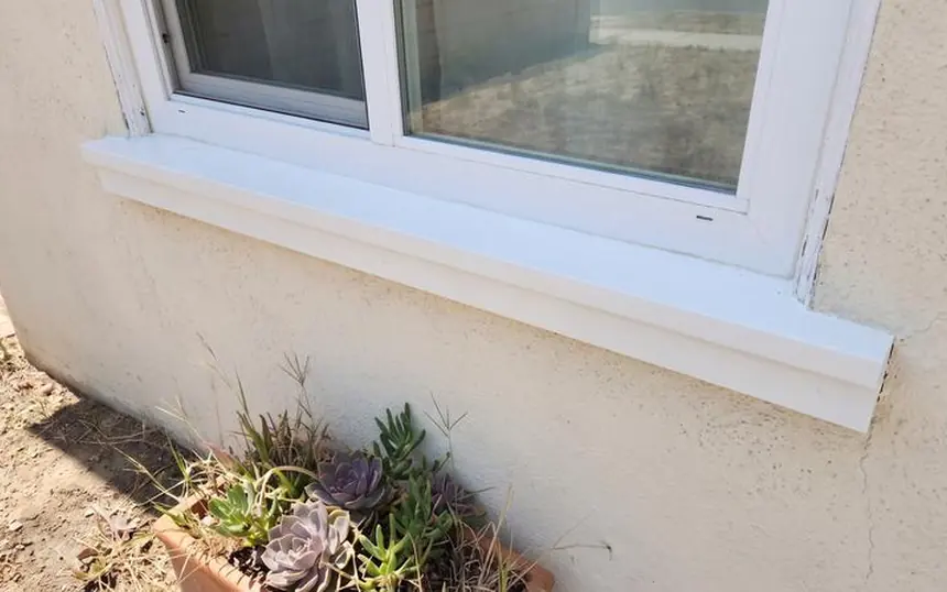 After: the same sill rebuilt, caulked and painted