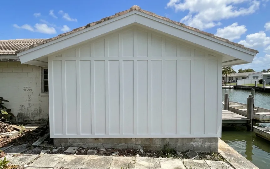 After: the same gable with new boards and battens, sealed and painted white, the fascia rebuilt