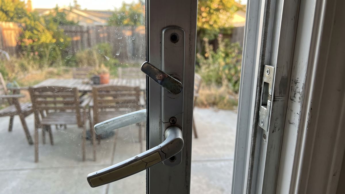 Cracked loose sliding patio door handle and misaligned latch before repair in San Diego