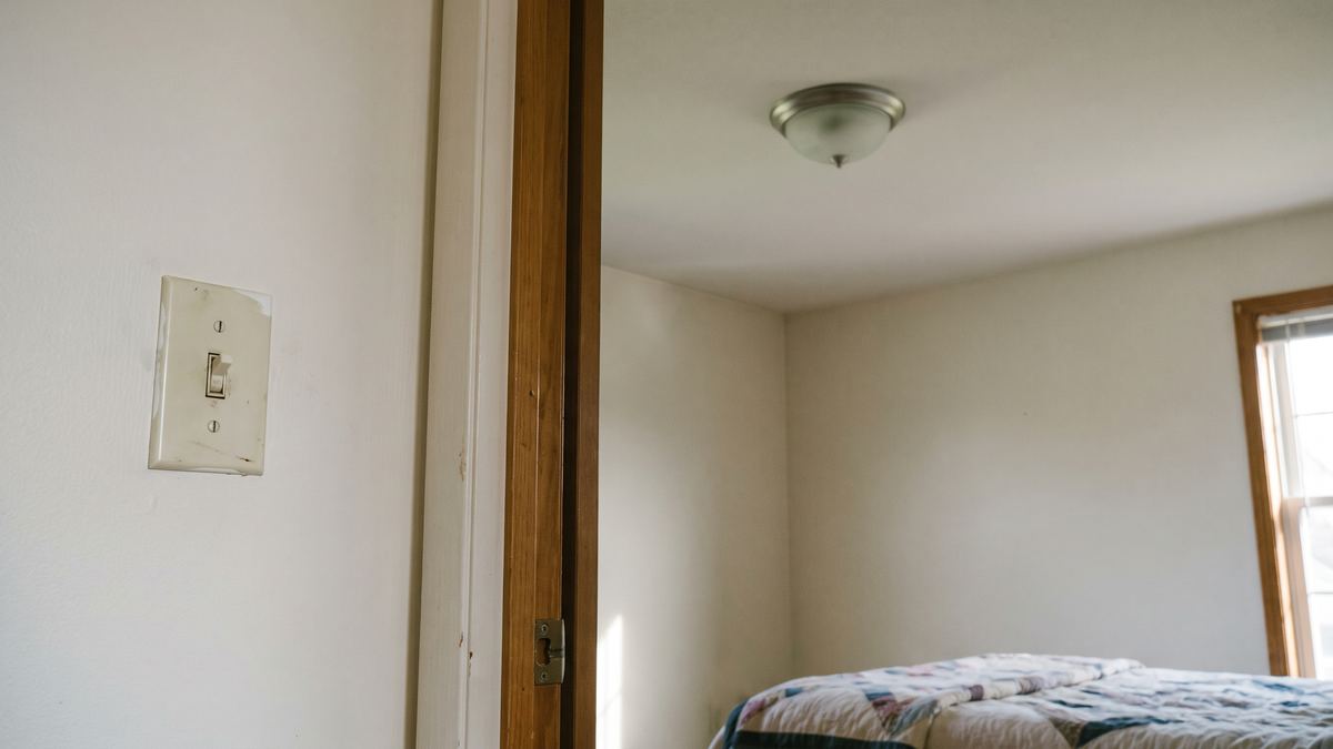 Bedroom doorway with an old toggle switch and the ceiling light turned off