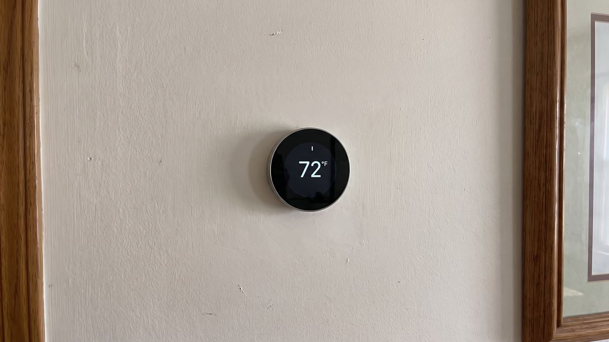Round smart thermostat installed on the same wall with the paint patched