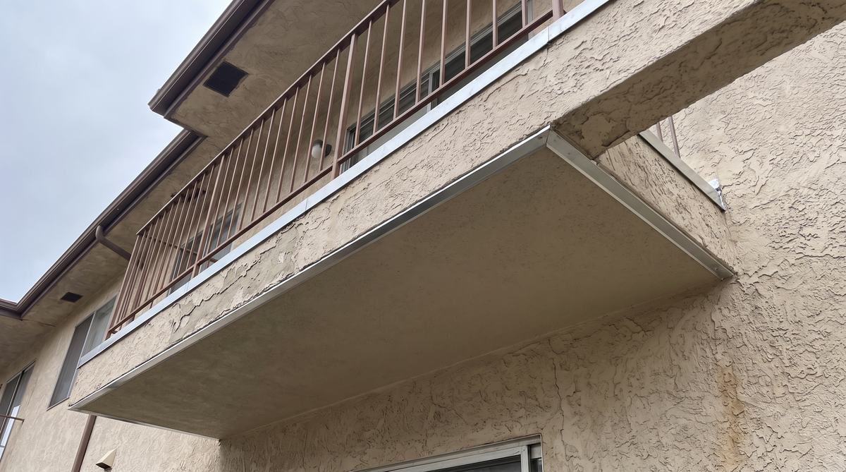 The same balcony rebuilt with new framing, waterproof deck coating and secured railing