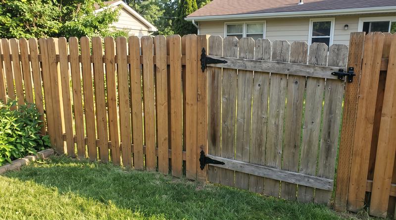 The same fence repaired, pickets replaced and gate rehung level