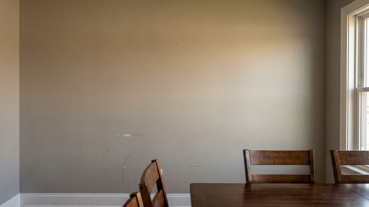 Plain dining room wall with scuffed paint before wainscoting