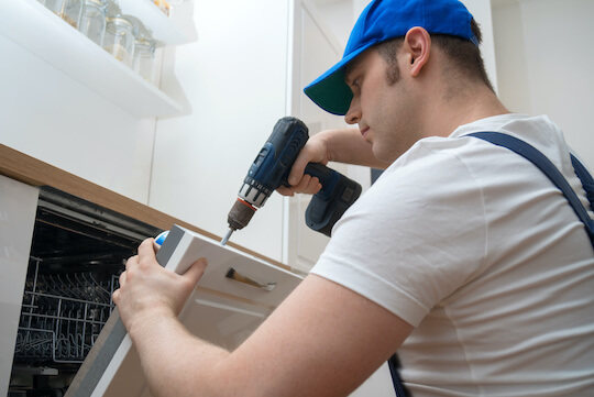 Handyman fixing dishwasher