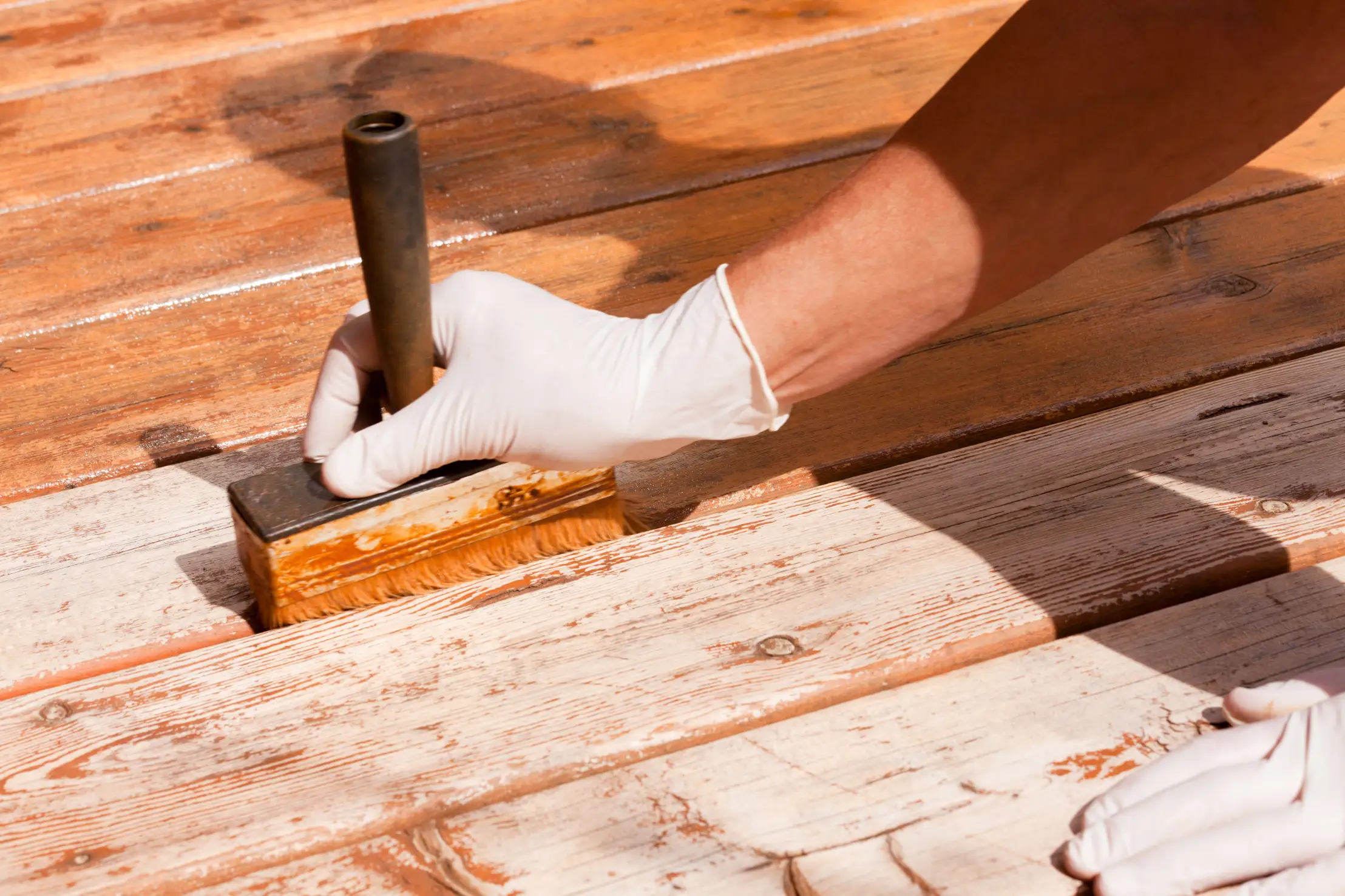 Technician applying sealant to a wooden deck
