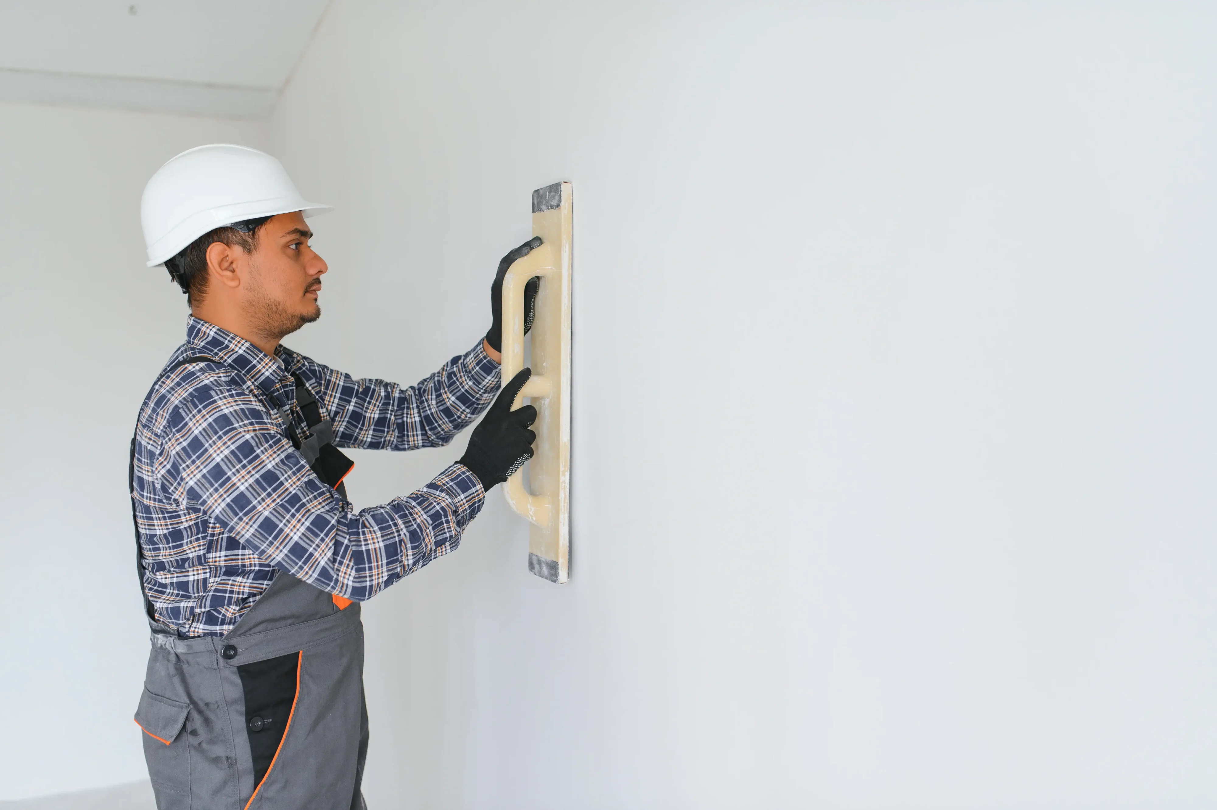 Drywall repair patch being sanded smooth in San Diego home — before and after comparison