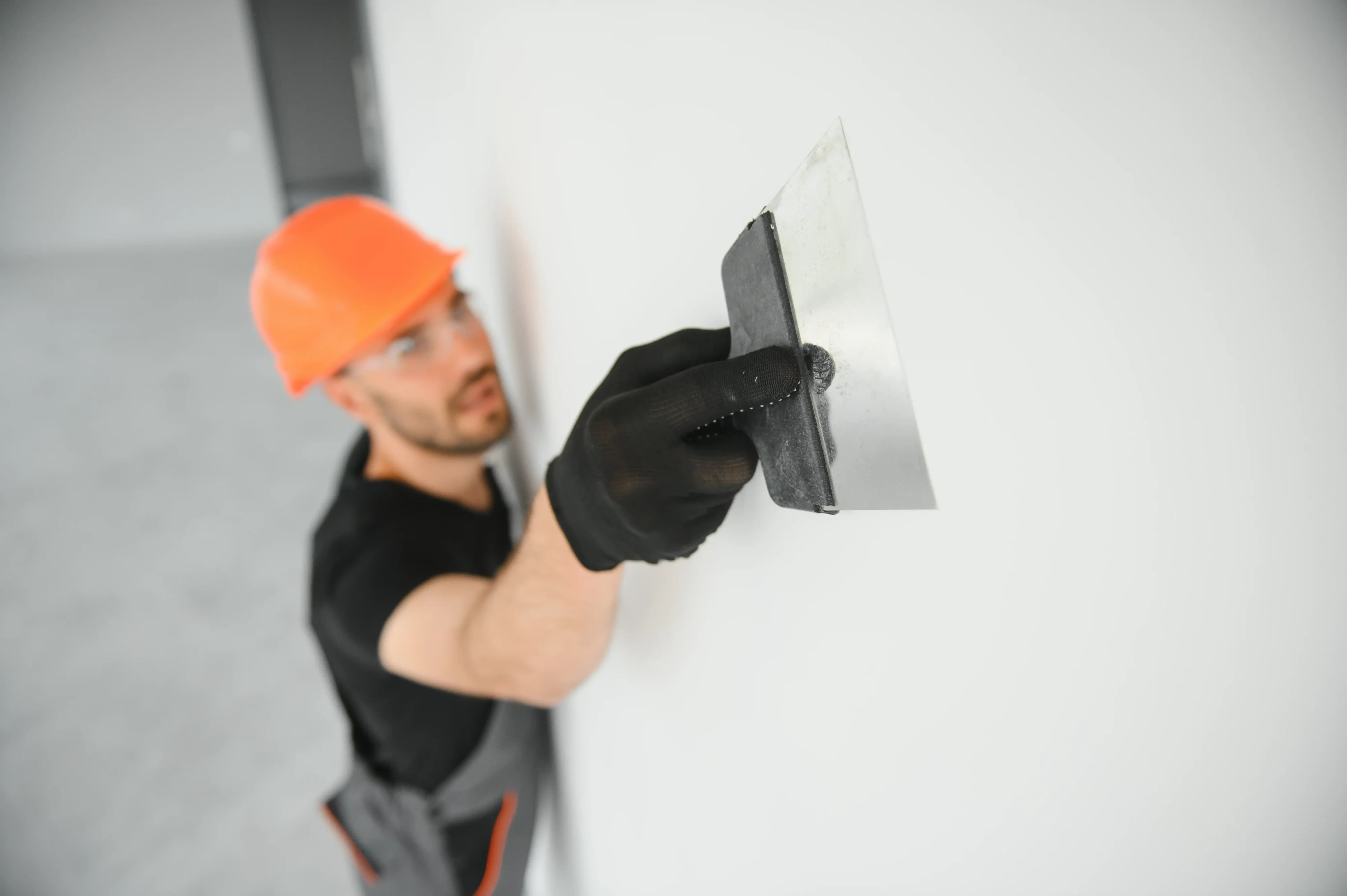 Technician finishing drywall repair on an interior wall