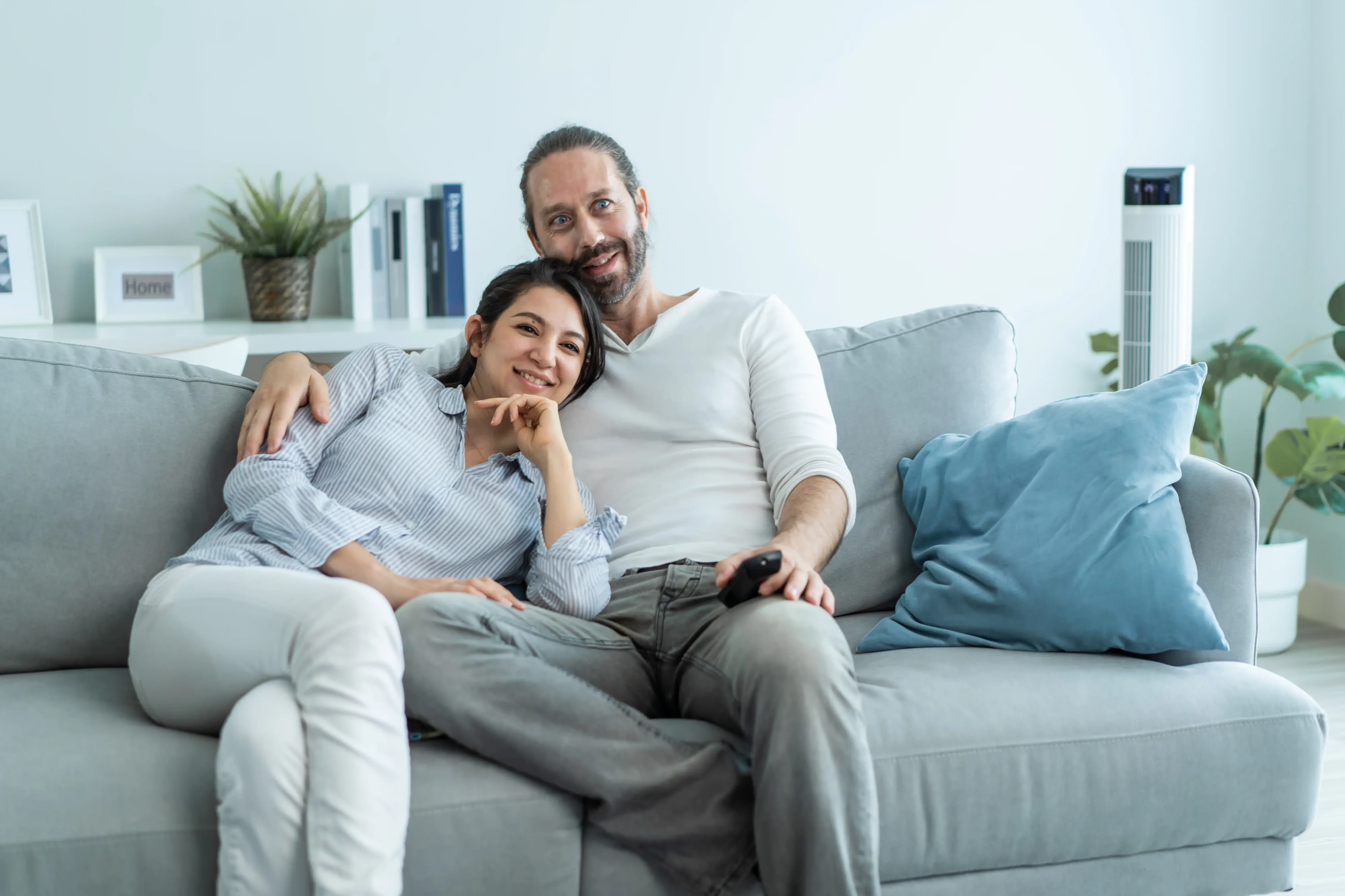 Happy middle-aged couple relaxing together in their living room with flawless walls