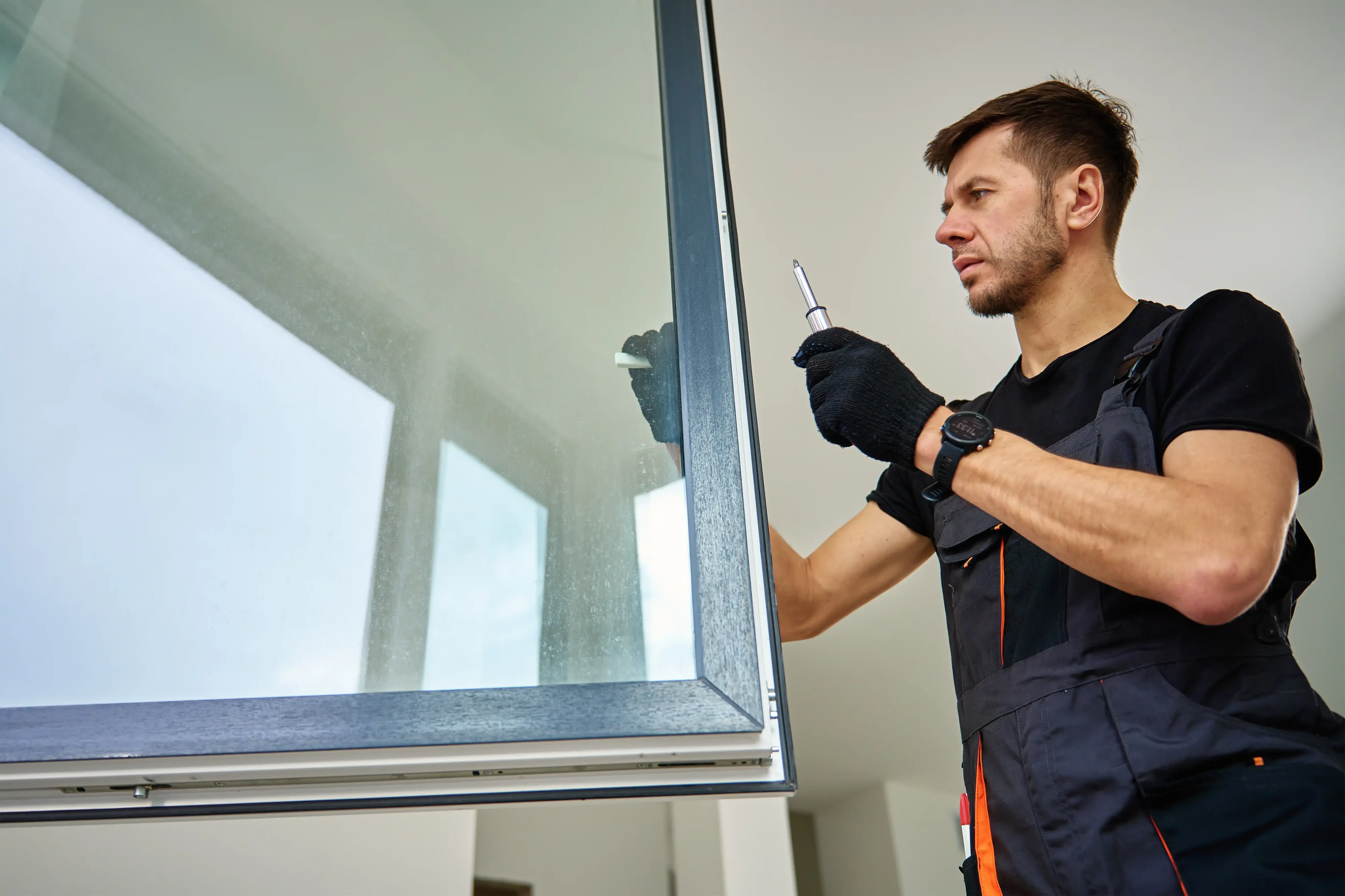 Technician working on a window with a screwdriver