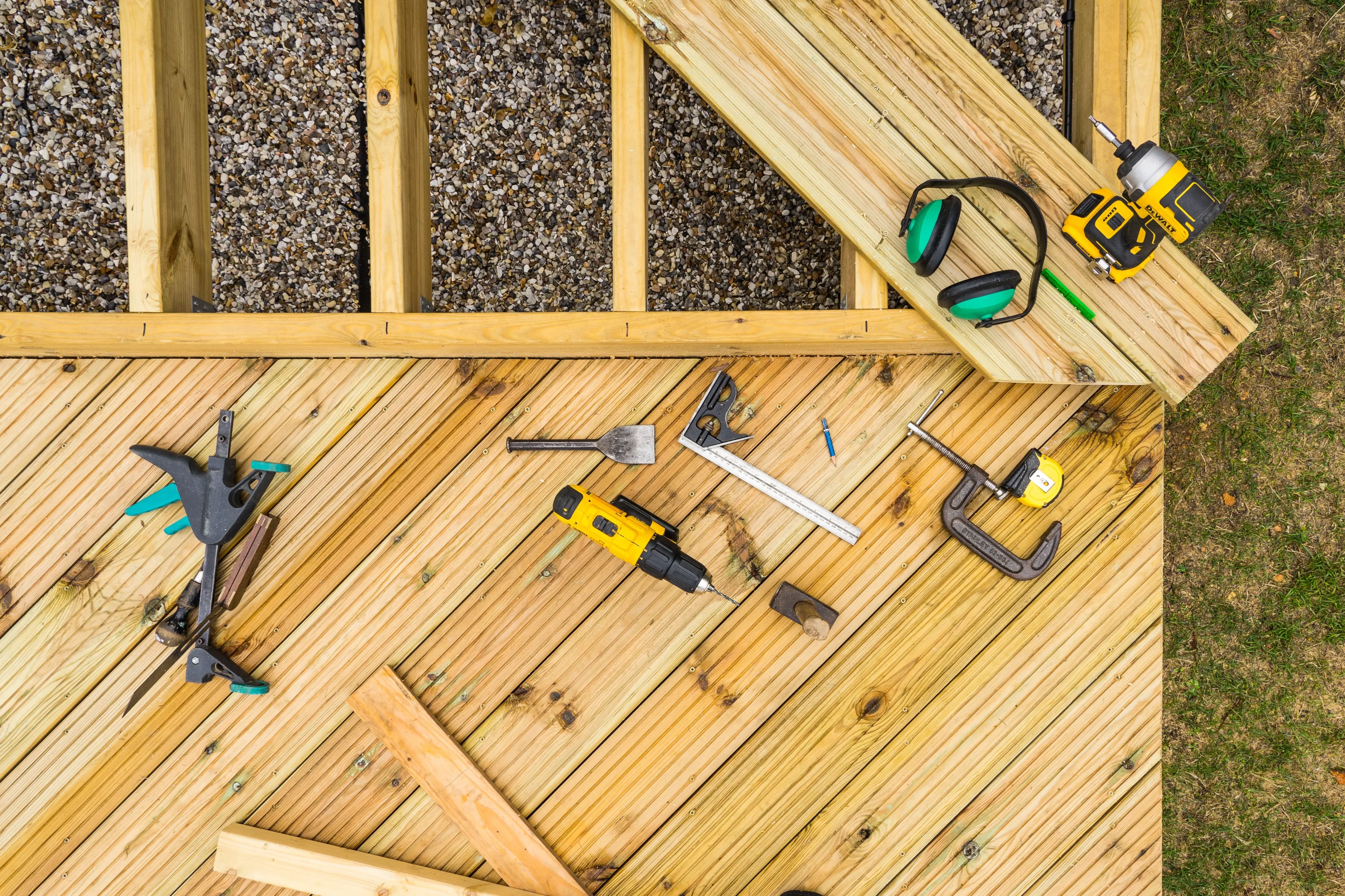 Wooden deck construction with tools laid out on the planks — before and after comparison